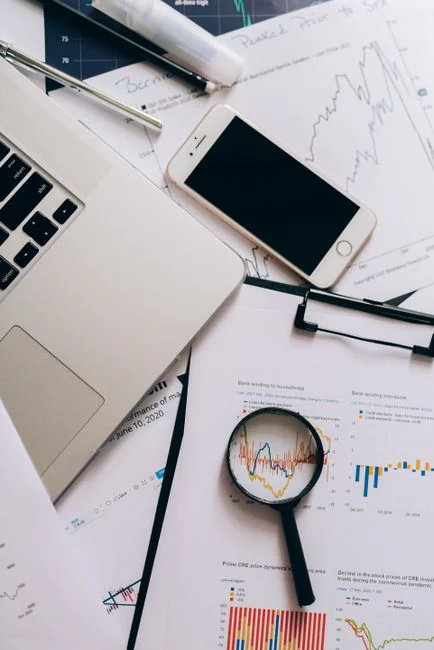Image centrée sur des mains examinant des graphiques et diagrammes d'affaires dans un classeur, mettant en avant les analyses de données.